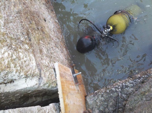 buceador con una bombona amarilla a punto de sumergirse